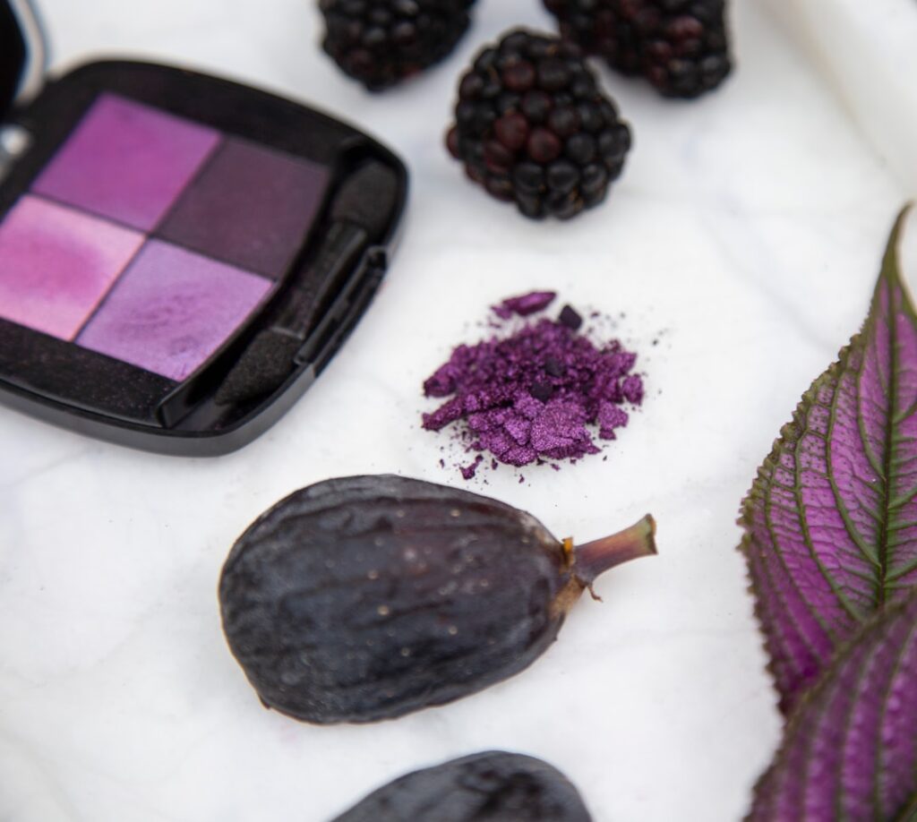 챗헷 - black and purple round fruit beside purple and black eyeshadow palette